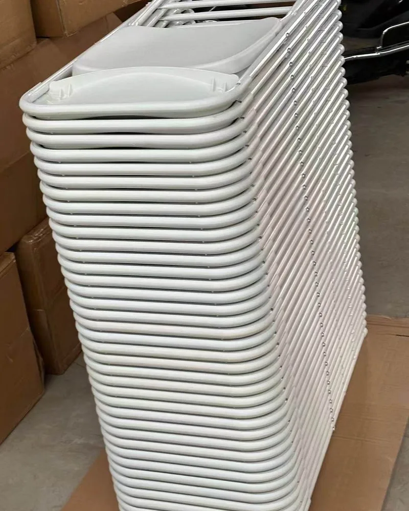 Tall stack of white folding chairs ready for shipment