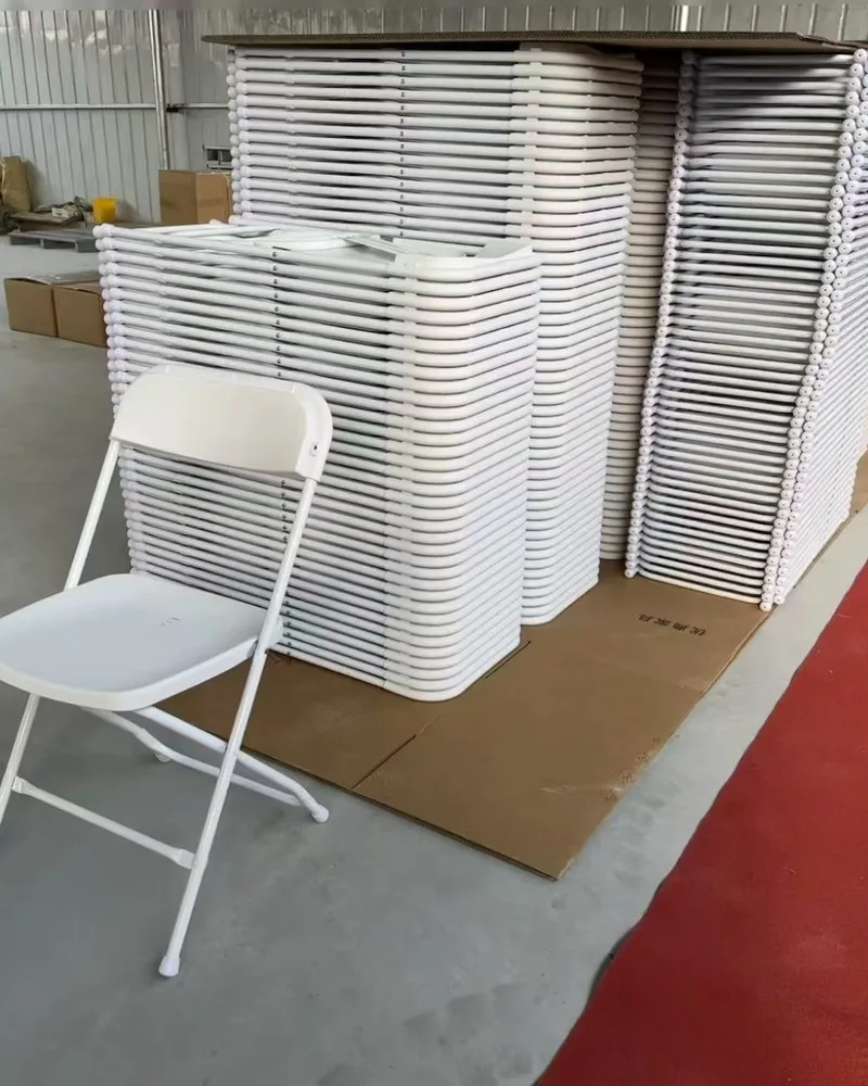Stacks of white folding chairs in a warehouse